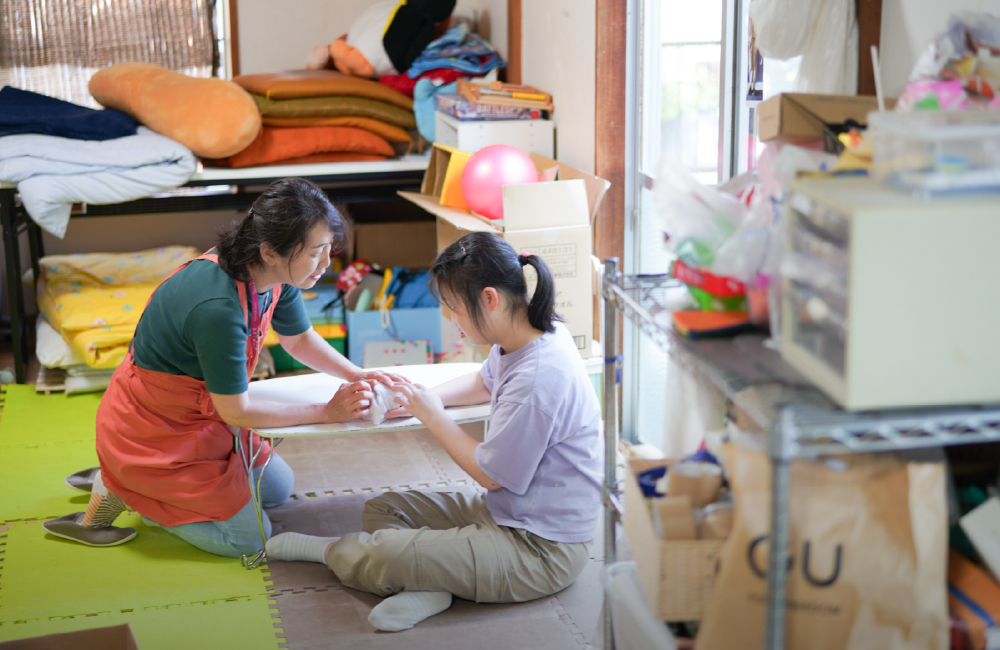 絵を描く利用者さんとスタッフの様子