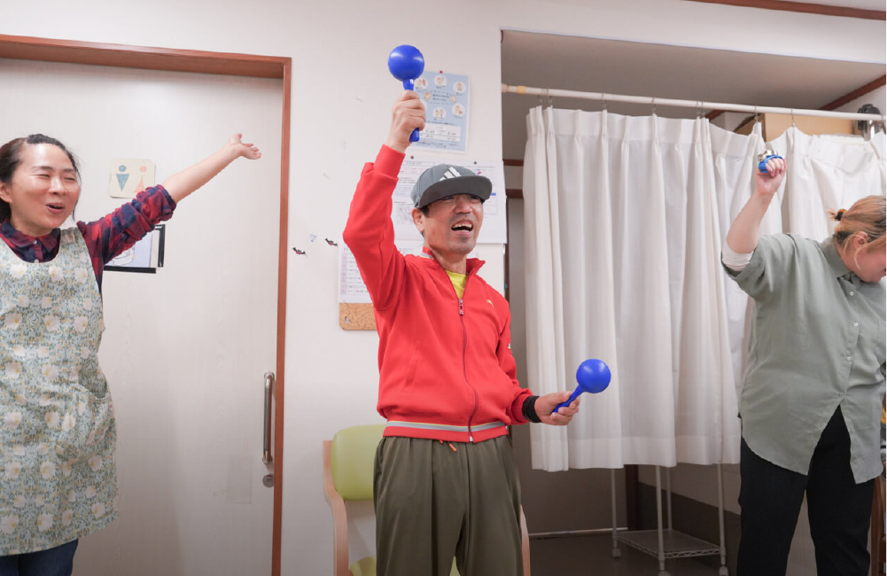 音楽に合わせて楽しそうに踊る利用者さんとスタッフ