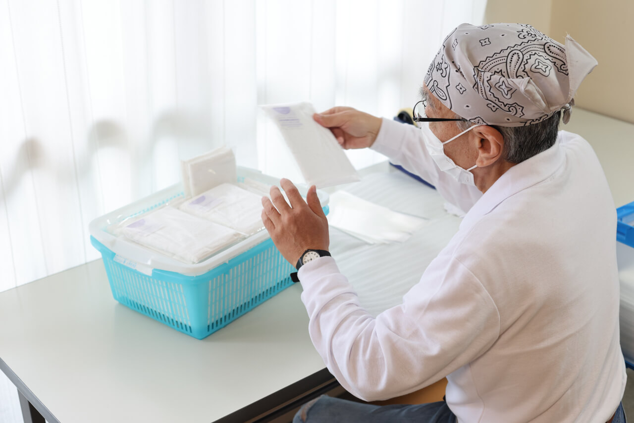 タオルの袋詰め作業をする利用者様の様子