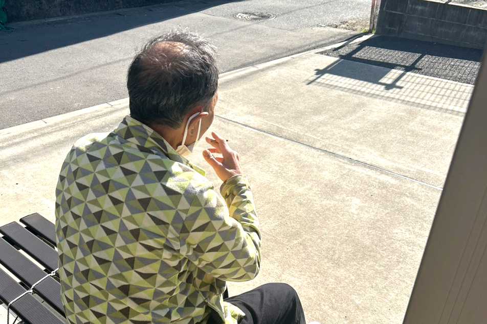喫煙スペースに座る利用者さまの様子