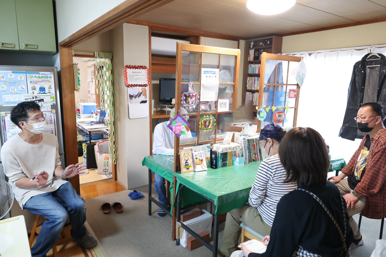 利用者さま、スタッフで向かい合い朝のミーティングをする様子