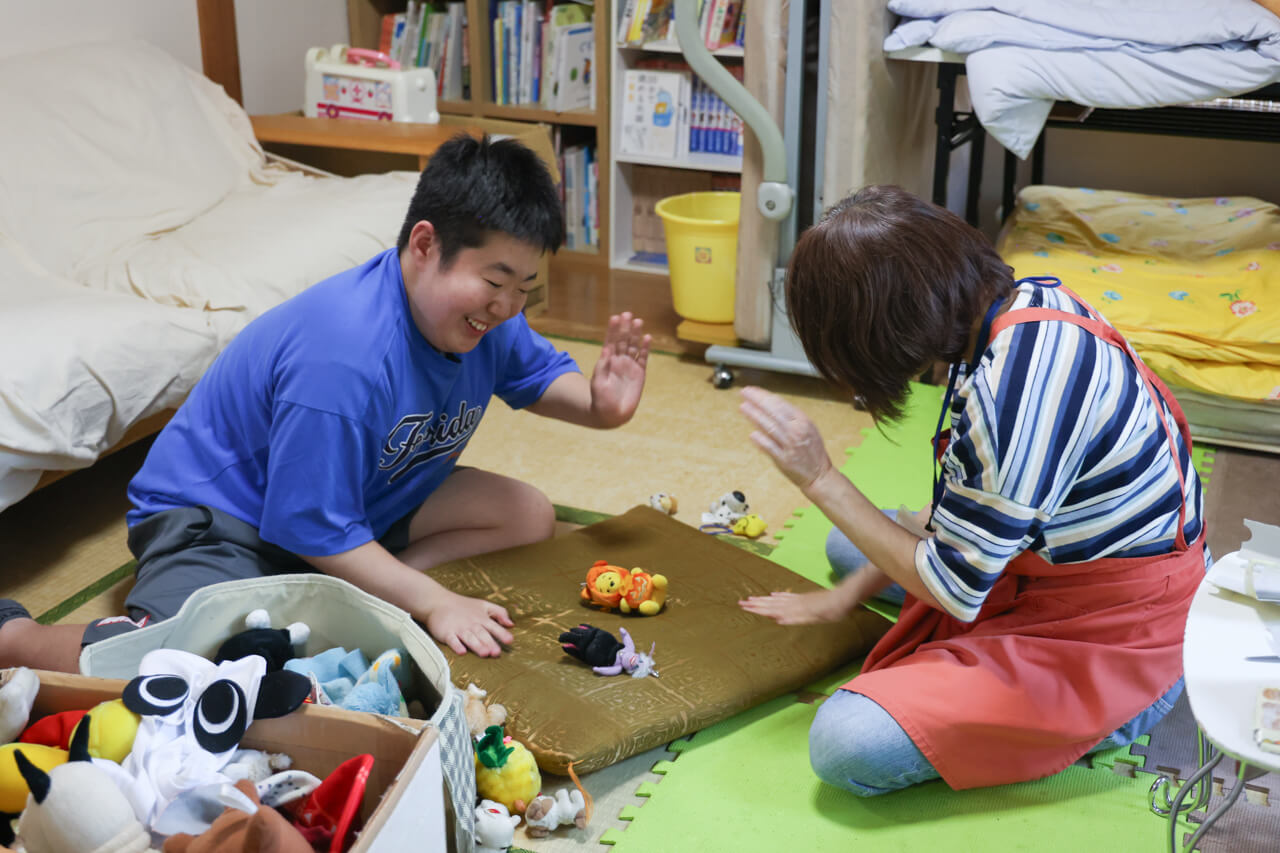 小さなぬいぐるみで遊ぶ利用者様とスタッフ